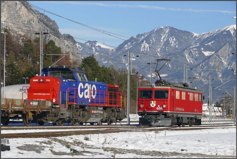 Whrend die Ge 4/4 I 606  Kesch  nach Chur zurckkehrt, schiebt die normalspurige Am 843 090-2 mittels eines bergangswagens die schmalspurigen RhB Wagen ber das Dreischienengleis in die Sgerei. (27.11.2008)