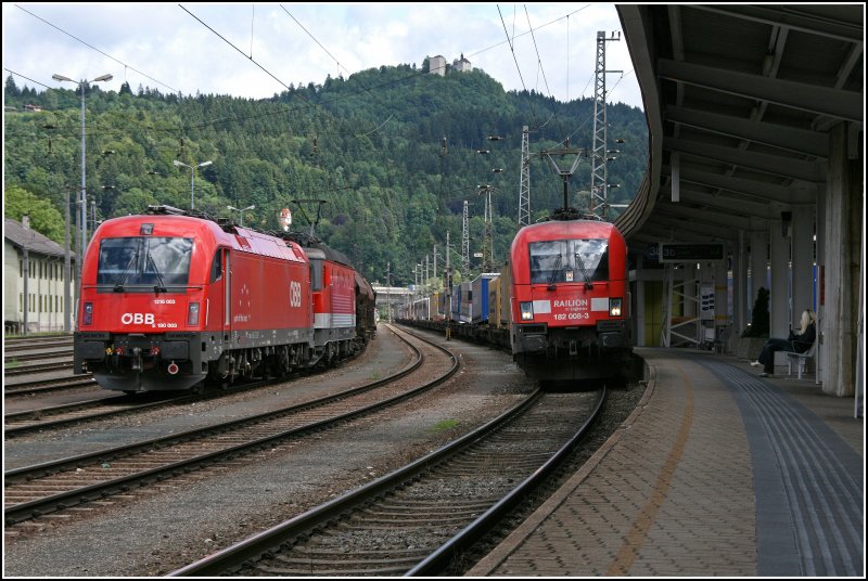 Whrend die Innsbrucker E190 003 an die Bludenzer 1144 231 angsetzt hat, rollt die 9180 6 182 008-3-D-DB mit einem Kombizug durch den Bahnhof. Vermutlich wird in Wrgel eine Vorspann- und eine Schiebelok an den Zug angsetzt, da das Zuggewicht etwas zu schwer sein drfte.