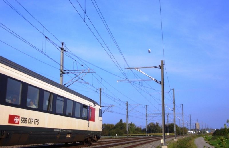 Whrend der letzte Wagen des IR 2136 die Tgerwiler Kurve bald passiert hat, schwebt der Zeppelin dem Zug nach. 19.09.09.