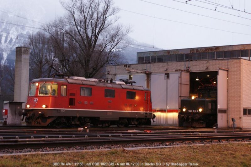 Whrend die SBB Re 4/4  11158 auf die Ankunft des EC 162  Transalpin  aus Wien WestBhf wartet, ist die Museumslokomotive 1020 042-6 noch daran, die Dampflok 77.250 ins Depot zu verschieben.
Buchs SG 06.12.08