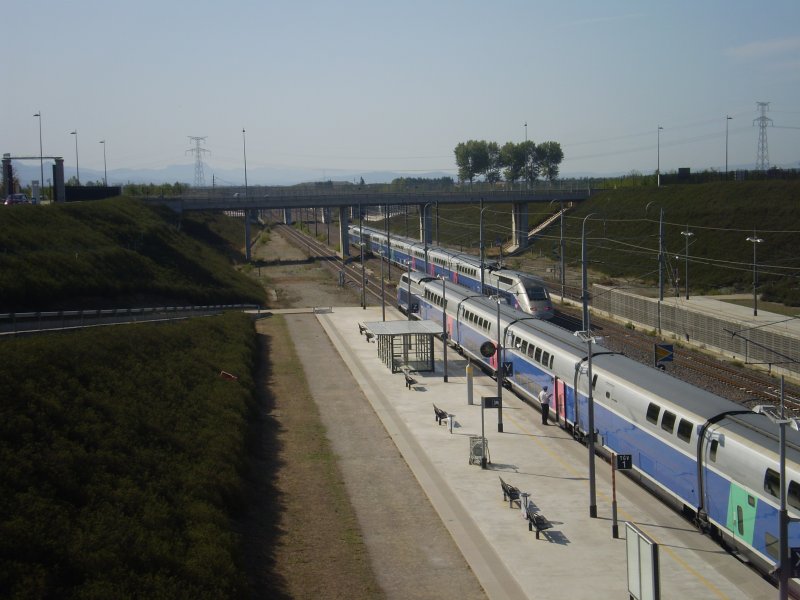 Whrend der eine TGV auf seine Abfahrt wartet, rast ein anderer TGV in Richtung Marseille durch den Bahnhof Valence (TGV). 
