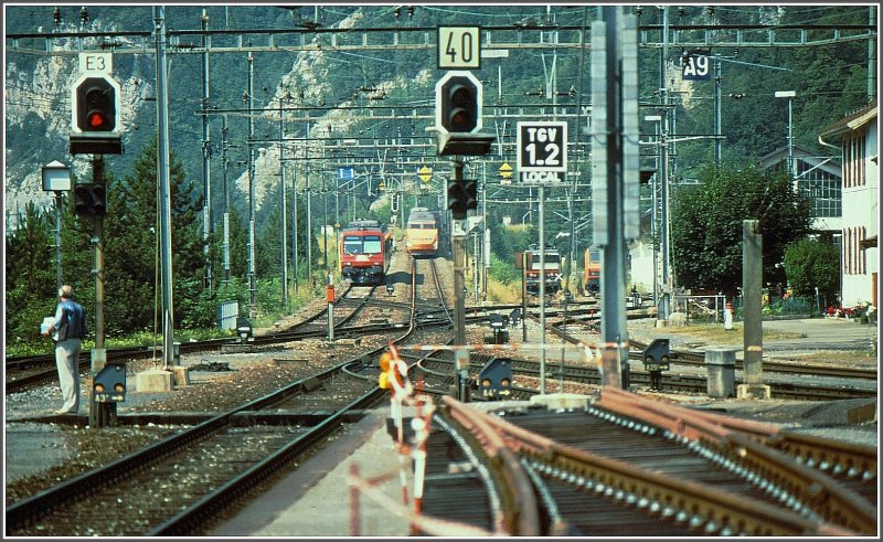 Whrend der TGV die Rampe Richtung Mont d`Or Tunnel erklimmt, warten der PBr NPZ und rechts zwei SNCF Maschinen. (Archiv 08/94)