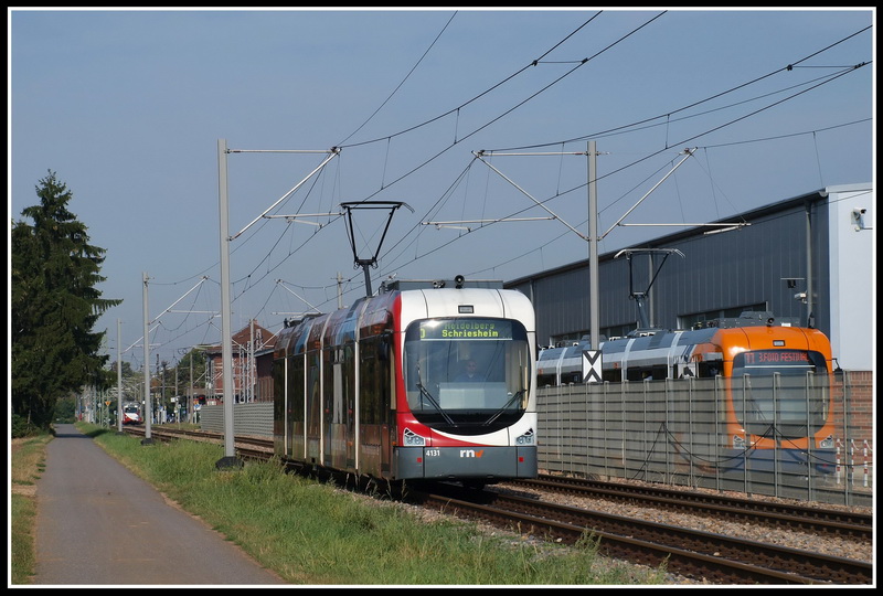 W�hrend der Tw 131 gerade Richtung Heidelberg unterwegs ist, steht neben der Wagenhalle ein neuer RNV8, der anscheinend ausgiebig getestet wurde. Edingen, 7.9.09