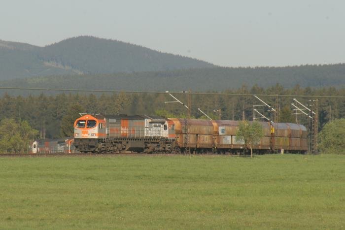 Whrend die Zuglok - V330.3 - den hchsten Punkt der Rbelandbahn berwunden hat und in die Gefllestrecke geht, schiebt V330.2 noch krftig nach. Nach dem berwinden des Scheitelpunktes gibt sie ihre Schubleistung auf und wird ein paar Kilometer weiter, auf der 51 Promille-Rampe zwischen Elbingerode West und Elbingerode HBF, als Bremslok wirksam.
An dieser Stelle zweigte frher die Stichbahn nach Drei-Annen-Hohne ab. Ende der 60er Jahre wurde hier ein elektrifizierter Stich zum Schacht III der Eisenerzgrube Bchenberg gebaut. Hier sollten jhrlich 1 Mio Tonnen Eisenerz ber die Rbelandbahn abtransportiert werden. Doch bevor das Schachtgerst gestellt wurde, kam berraschend das Aus fr den Elbingerder Eisenerzbergbau. Neben der 70 Mio Mark Investruine wurden auch einige Maschinen der BR E251 zu viel gebaut und es stand nun dem BW Blankenburg ein Lokomotivberbestand zur Verfgung. Da die Maschinen auf keiner anderen Strecke in der DDR eingesetzt werden konnten, wurde der berbestand auch nicht abgezogen.