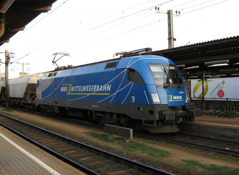 Weit weg von zu Haus. Taurus 1116 911-7 der Mittelweserbahn (MWB) mit Getreidezug beim Tf-Wechsel-Halt in Wien Htteldorf. 06.04.2009.