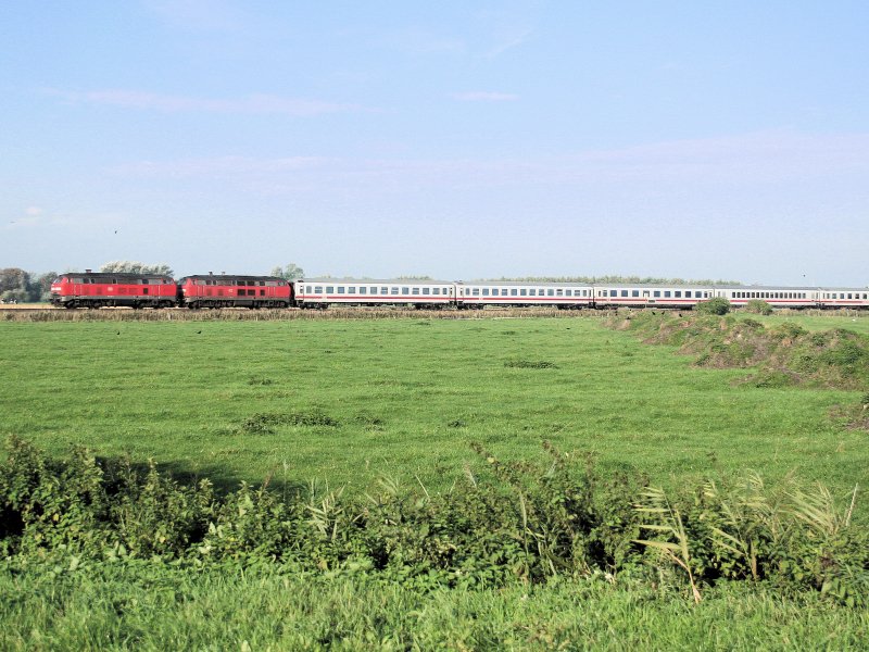 Weites Land... Zwei 218er ziehen einen Intercity auf der Marschbahn in Richtung Hamburg. Der Zug befindet sich zwischen Husum und Friedrichstadt.