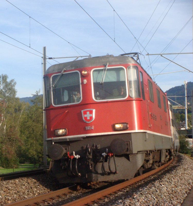Wenn man beim fotografieren gefilmt wird: In der Re 4/4 II, die am 21.09.2007 mit dem EC Transalpin bei Altendorf unterwegs ist, filmt jemand aus dem linken Fhrerstandsfenster wohl die Strecke, die Kamera guckt aber genau auf mich...