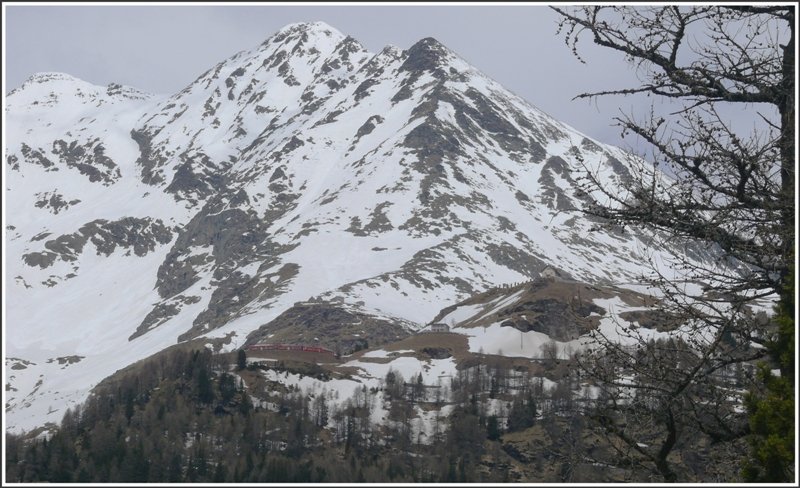 Wer entdeckt den BerninaExpress 953. Er fhrt soeben um die grosse Kurve bei Alp Grm unterhalb des 3031m hohen Sassal Mason. (06.05.2009) Aufgenommen vom Gletschermhlenpark in Cavaglia 400m tiefer.