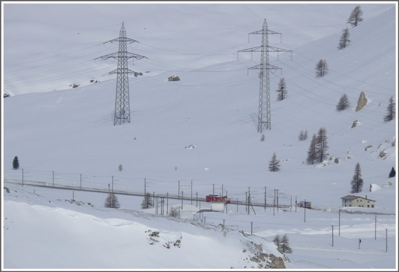 Wer genau hinschaut, entdeckt nach der Station Bernina Lagalb die Gem 4/4 802 mit der Schneeschleuder auf der Rckfahrt nach Pontresina. Hier erkennt man auch die riesigen Ausmasse der Masten der Starkstromleitung ber den Berninapass. (10.03.2009)