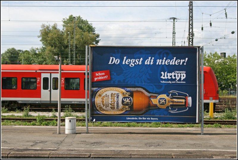 Werbeplakat in Rosenheim. Im Hintergrund wartet 426 032 auf neue Aufgaben. (03.07.07)
