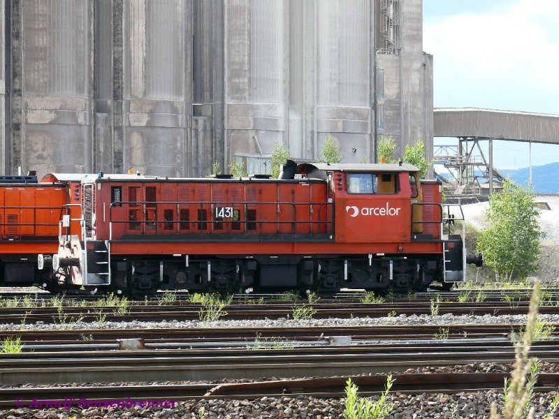 Werksdiesellok 1431 des Stahlwerks Arcelor-Mittal in Florange-Ebange.
Florange-Ebange (deutsch Flrchingen-Ebingen), nahe bei Thionville (Diedenhofen) an der Mndung der Fensch in die Mosel gelegen, wurde in den 1950/60er Jahren zu einem Zentrum der lothringischen Schwerindustrie ausgebaut. Das Stahlwerk gehrt heute zu Arcelor-Mittal.
30.07.2007
