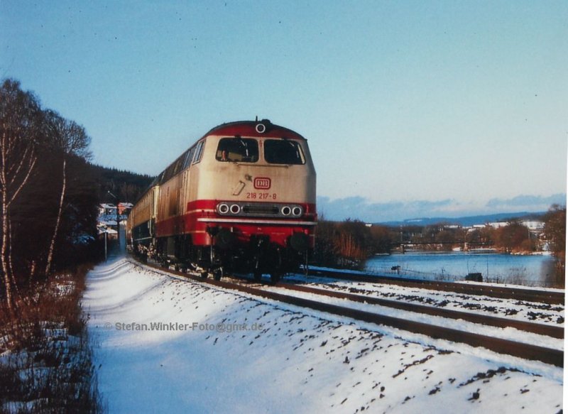 Winter 1983/84 in der guten alten DB-Zeit. 218217, das Einzelstck im TEE-Look zieht D 466 an der Naab bei Pfreimd entlang. Rechts eine alte Straen-gitterbrcke ber den Fluss. Aufnahme vom 23.01.1984 aus dem Dia-Archiv....