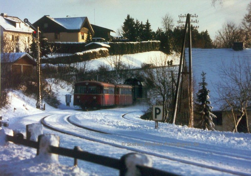 Winter 1992/93, der letzte Einsatzwinter der Schienenbusse des Bw Hof. Kurz vor Einsatzende hatte ich zufällig Glück und konnte diesen Zug am ESig Naila fotografieren, der mit einer 211 verstärkt war. Heute ist die rechts zu sehende Strecke nach Schwarzenbach am Wald Geschichte, sogar das Signal hat Funktion und Flügel verloren. Aber immerhin fahren hier noch 628.2. 628.4 und 612. Ab 2011 geht es hier mit kleineren neuen Fahrzeugen weiter... Der graue Star hat die Ausschreibung gewonnen. Mal sehen, wie man den immensen Schülerverkehr in den Griff bekommen will.....