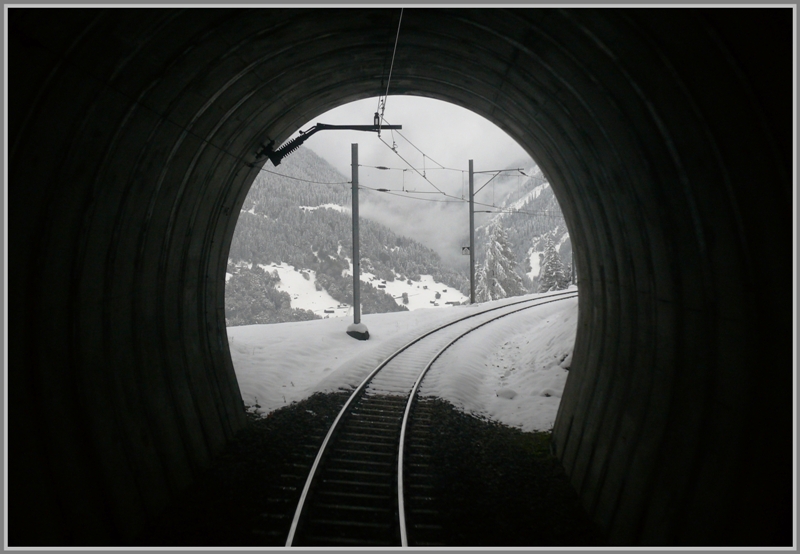 Winterimpressionen zwischen Davos und Klosters. Licht am Ende des Tunnels. Ausblick aus dem Cavadrlitunnel, fotografiert durch das Fenster der hintersten Wagentre von RE1052. (18.10.2009)
