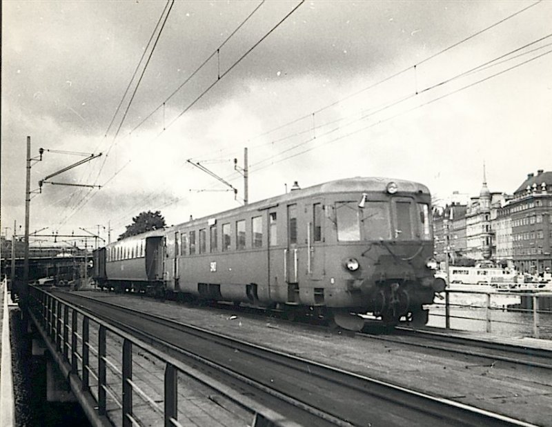 Wir sind im Sommer 1960 : aus dem Zentralen Bahnhof Stockholm kommt diesen Tw Richtung Nynshamn. SNJ (Stockholm-Nynshamn Jrnvg (Bahn) war eine private Gesellschaft. Diese kurze Linie war in der Zeit noch nicht elektrifiziert. 
Foto : J.J. Barbieux