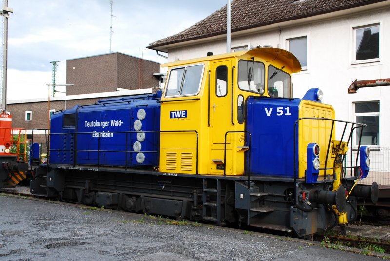Wirkt fast wie ein Kleinkind unter den Lokomotiven: Eine Mak G500C des Baujahres 1974 im schnen leuchtenden Blau-Gelb der Teutoburger-Wald-Eisenbahn. Die als V51 gekennzeichnete Lok steht hier im heimischen Bahnhof von Gtersloh auf einem Nebengleis geparkt. Eingesetzt wird sie berwiegend zum zusammenstellen von Gterzgen und fr Kurierfahrten mit einigen wenigen Wagon´s, die in der nheren Umgebung in andere Gterzge eingebunden werden. (10.06.2009)