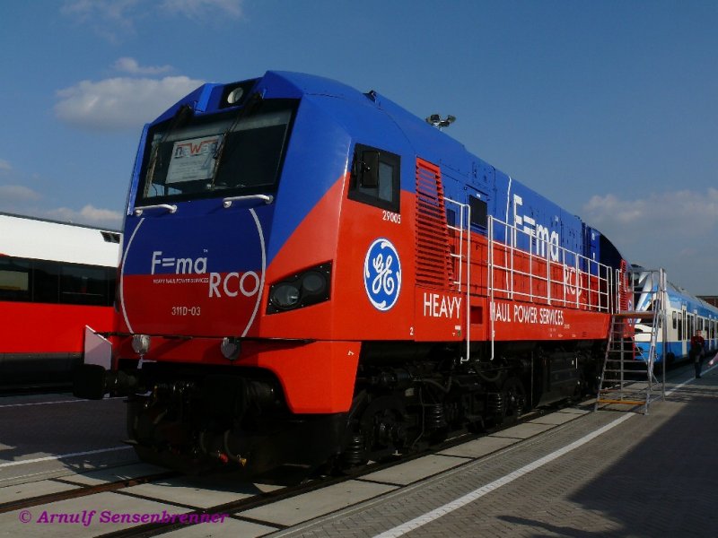Zahlreiche modernisierte Fahrzeuge waren auf der Innotrans-2008:
Hier die Diesellok 311D03, ein modernisierter Gagarin.

Seit 2006 fhrt die polnische Firma Newag, in Kooperation mit GE Transportation, an Dieselloks des Typs M62 (u.a. polnische Reihe ST44  Gagarin , Reichsbahn V200  Taigatrommel ) eine Radikalmodernisierung durch. Die Loks erhalten einen neuen Diesel und Generator und oberhalb des Rahmens einen komplett neuen Aufbau. 

Die umgebauten Loks tragen die Reihenbezeichnung 311D.
Die ausgestellte blau-rote Lok gehrt zu Kolej Baltycka (Baltic Rail), der polnischen Tochter von Heavy-Haul-Power. Sie trgt deren Werbung.

28.09.2008 INNOTRANS Berlin
