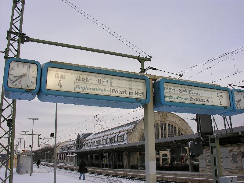 Zugzielanzeiger in Potsdam Park Sanssouci mit Fehlern. Danach wrden die Zge in Richtung Berlin im Minutentakt fahren. Der im linken Teil um 44 angekndigte Zug soll laut Aushangfahrplan bereits 38 abfahren. Da auch die Rckseite den gleichen Fehler zeigt, ist eine fehlerhafte Programmierung vermutlich die Ursache. Im Hintergrund ist der neu errichtete Kaiserbahhof zu sehen.