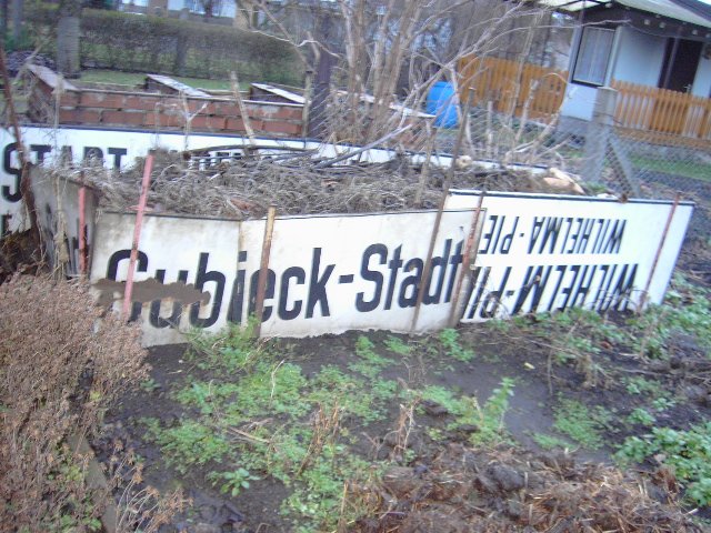 Zweckentfremdete Bahnhofschilder als Komposthaufenumrandung in einer Gartenanlage am Rande des Bahnhofs Guben.
Wortlaut richtig: Wilhelm-Pieck-Stadt Guben, Wilhelma-Pieckowe-Msto Gubin
