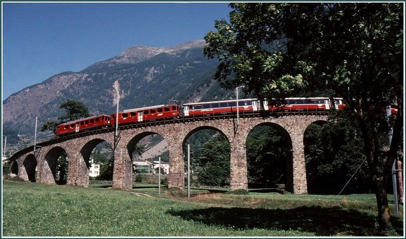 Zwei ABe 4/4 II fahren mit einem Bernina Express der neunziger Jahre ber das Kreisviadukt von Brusio talwrts. (Archiv 09/89)