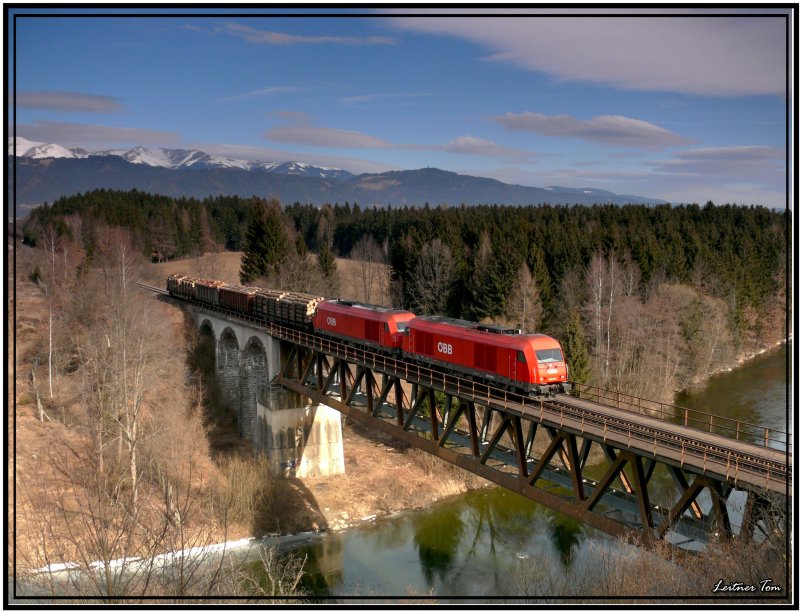 Zwei Dieselloks der Baureihe 2016 fahren mit einem kurzen Holzzug ber die Murbrcke bei Zeltweg in Richtung Lavanttal.
18.2.2008