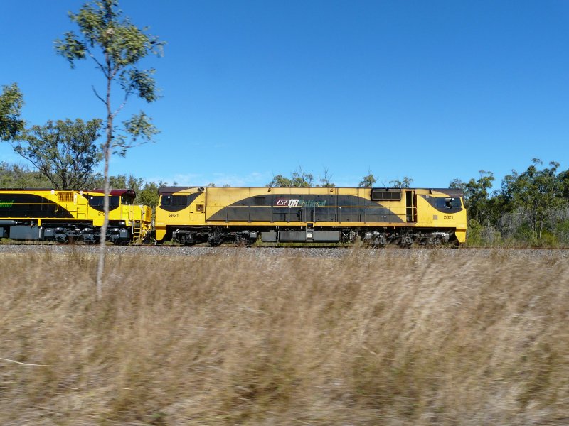 Zwei Queensland Rail Loks ziehen am 5.7.2009 einen Containerzug in Richtung Townsville. Aus dem Autofenster vom Bruce Highway fotografiert.