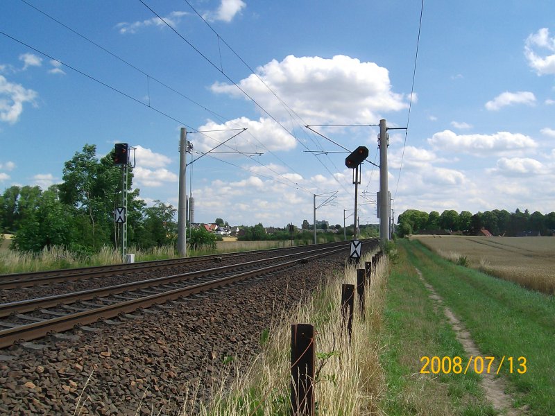 Zwei Vorsignale und dahinter zwei Abspannmasten fr die Oberleitung auf der Kbs 140 kurz vor Reinfeld (Holst). 13.07.08.