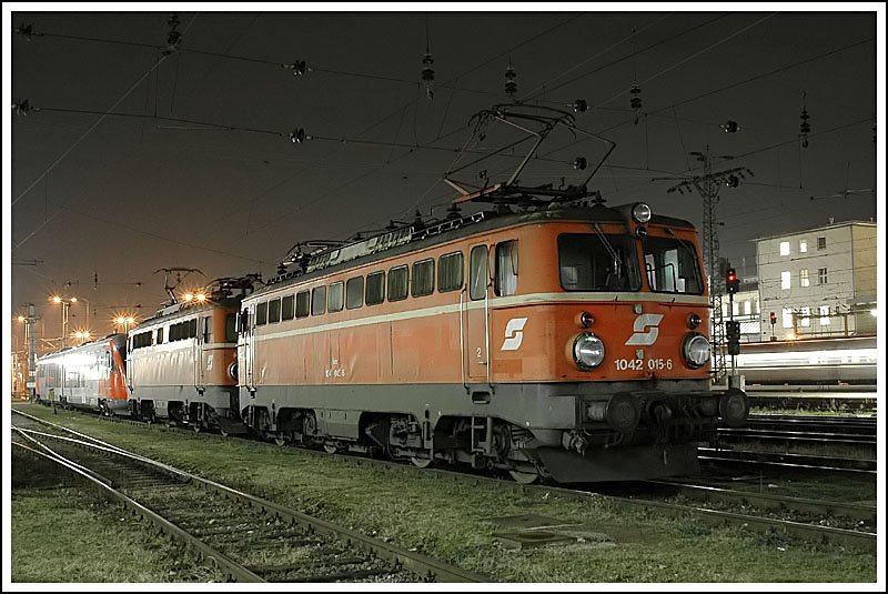 Zweimal 1042 mit Altlack. 1042 015, dahinter 1042 050 und ein Triebwagen der Reihe 5022 Desiro, abgestellt am 12.12.2006 in der Traktion des Grazer Haupbahnhofes.