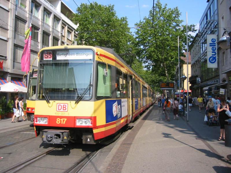 Zweisystem-Stadtbahn des Karlsruher Verkehrs Verbundes (KVV) am 05.08.2004 an der Haltestelle Marktplatz in der Karlsruher Innenstadt. Der Zug der Linie S 5 hat Bietigheim-Bissingen zum Ziel. Auch Wagen 817 gehrt nicht der Albtal Verkehrs Gesellschaft (AVG), sondern DB Regio, einem der Verbund-Unternehmen. Die DB hat diese Fahrzeuge als Baureihe 450 eingereiht. Die DB-Betriebsnummer von Wagen 817 lautet 450 001.
