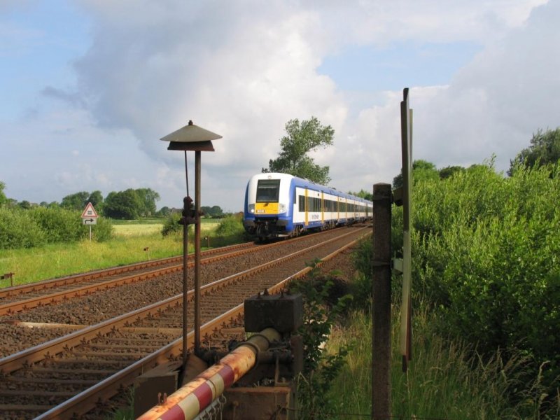 Zwischen die alte Bahnbergangssicherung durch ist die NOB 80502 Hamburg Altona-Westerland (Sylt) (geschoben durch die MAK DE 2700-11 der Nord-Ostsee-Bahn) bei West Bargum zu sehen am 22-6-2007.