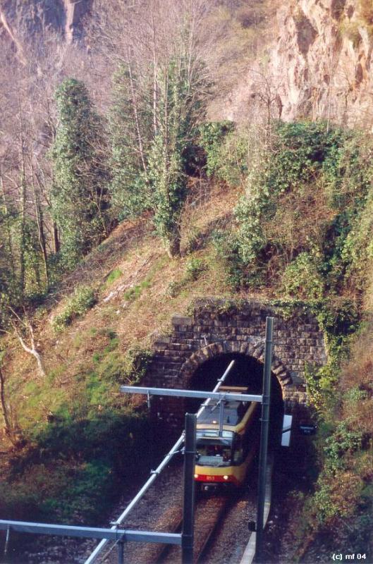 Zwischen den Tunneln -

S31, S41 Murgtalbahn. Südportal des Rappentunnels. Die Bahn wird gleich wieder im nächsten Tunnel (Hackentunnel) verschwinden, um dann den neuen Halt Gausbach zu erreichen. Die Stromschiene wurde auch im offenen Bereich durchgezogen.

Frühjahr 2004 (M)