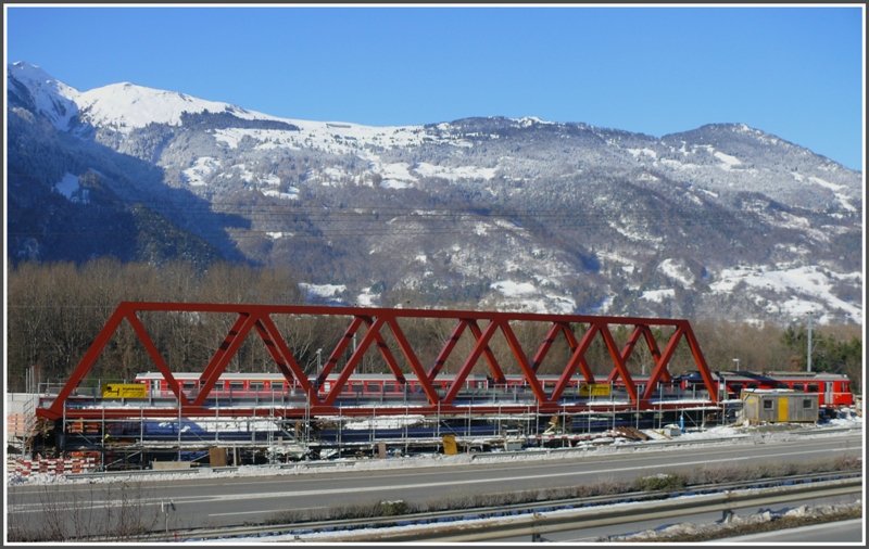 Zwischen Untervaz-Trimmis und Zizers wird parallel zur Autobahn eine neue RhB Brcke gebaut. Der Regio 1530 befindet sich dahinter auf der alten und wesentlich krzeren Brcke ber die SBB Doppelspur Chur-Landquart. Nach Fertigstellung wird die neue gebogene Brcke an ihre definitive Lage verschwenkt. (27.11.2008)